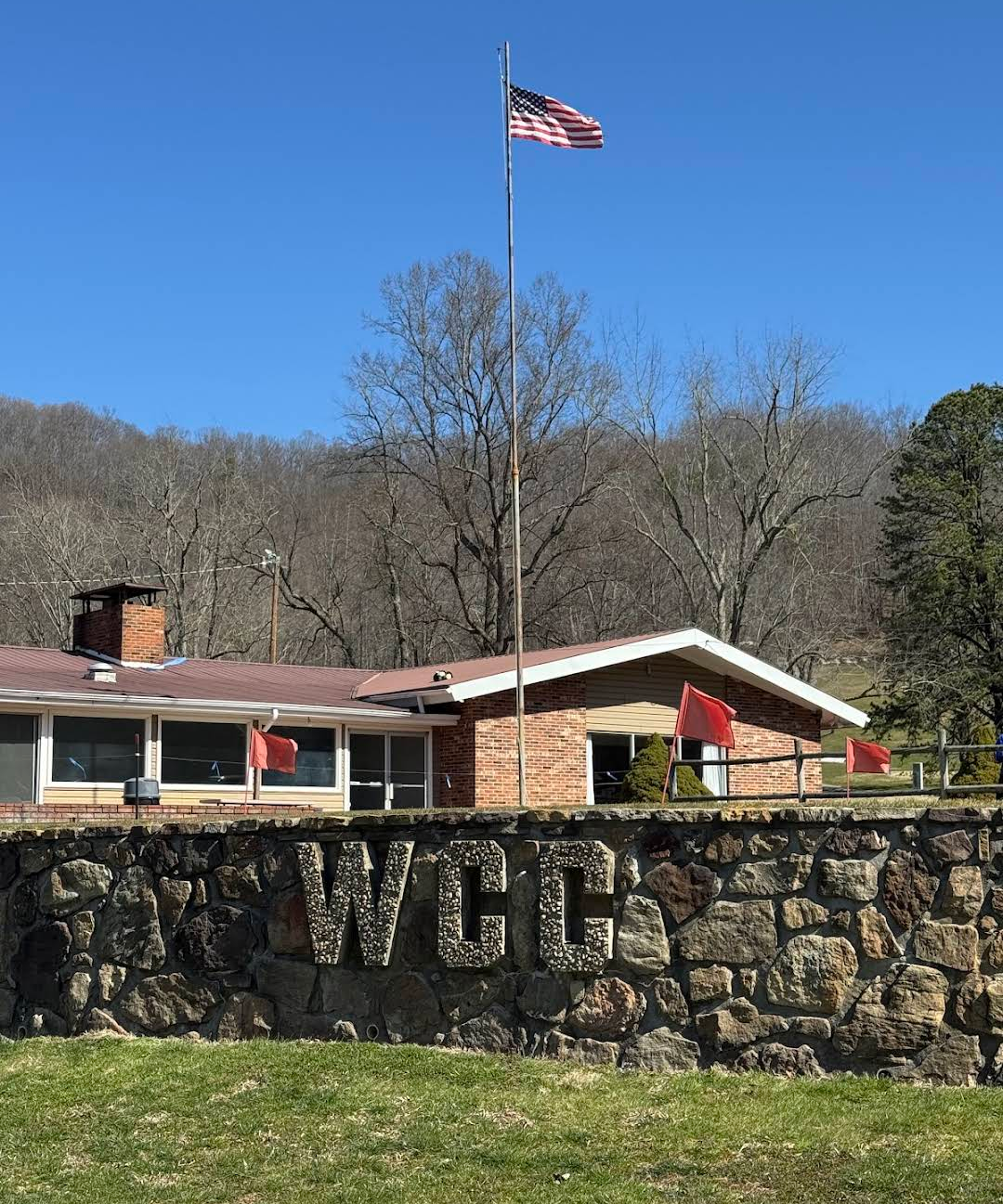 Willowbrook Golf Course clubhouse with stone WCC wall and American flag