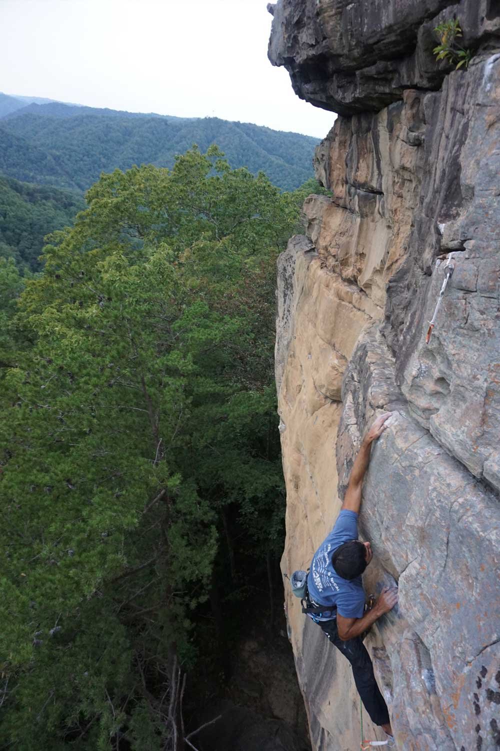 Rock climber scaling a sandstone wall at Breaks Interstate Park