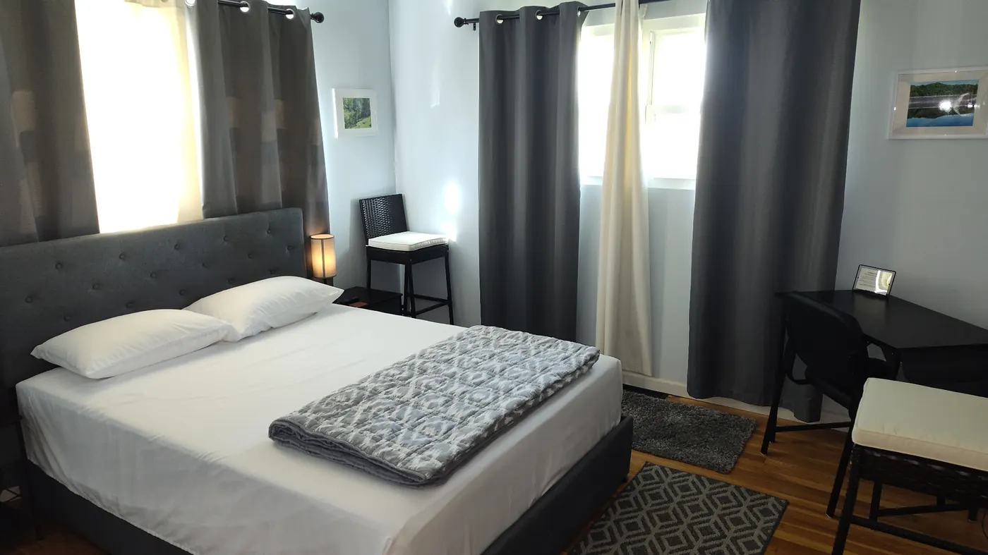 Suite bedroom with tufted headboard and natural light