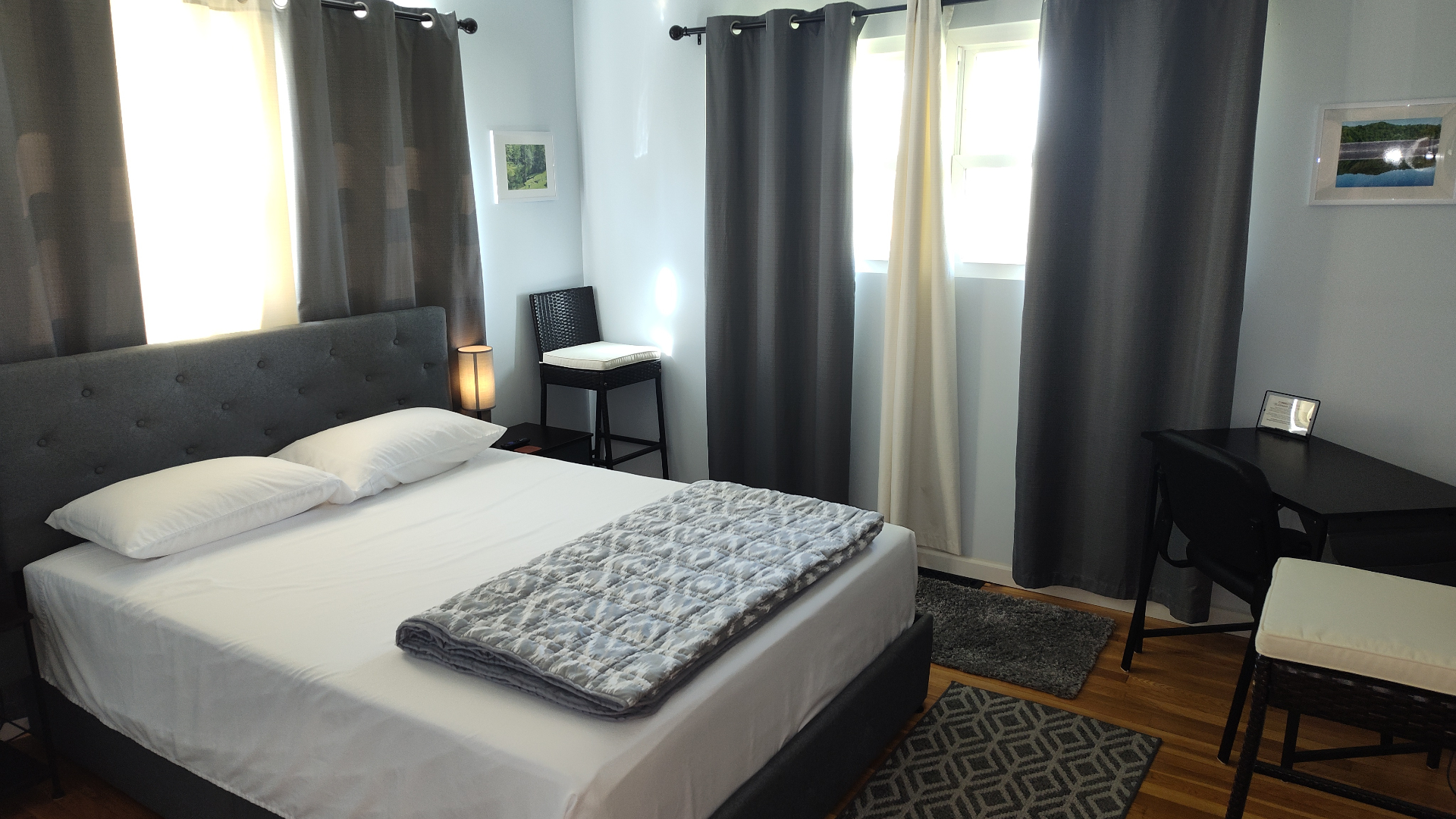 Suite bedroom with tufted headboard and natural light